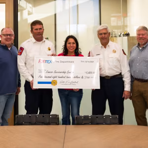 The fire department donated money raised from the “give cancer the axe” T-shirt fundraiser to 24 Hours in the Canyon Cancer Survivorship Center on December 11.