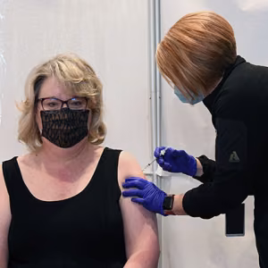 Michelle Reichert, CNS president and chief executive officer, receives her COVID-19 vaccination from a Pantex medical provider.