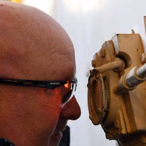 Deputy Site Manager Kenny Steward examines the sight glass, which give him a look inside one of the Pantex boilers.